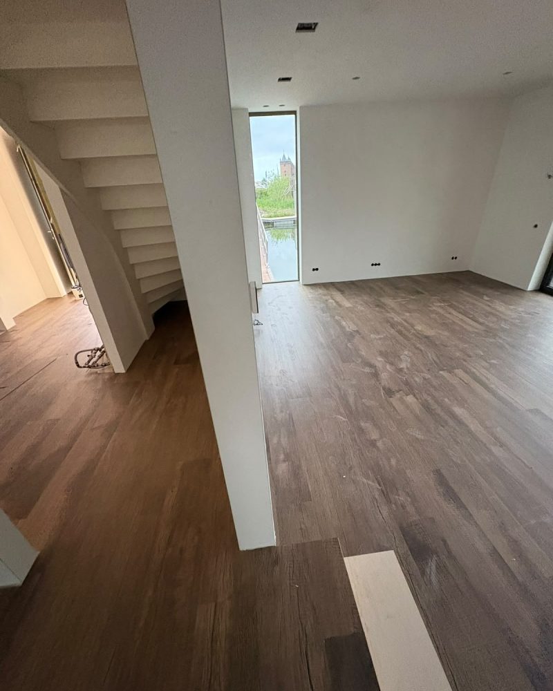 Donkere houtlook vloer woonkamer met trap