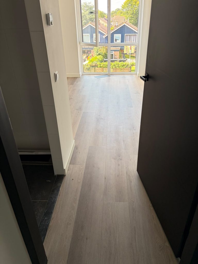 Lichte houtlook vloer gang met groot raam
