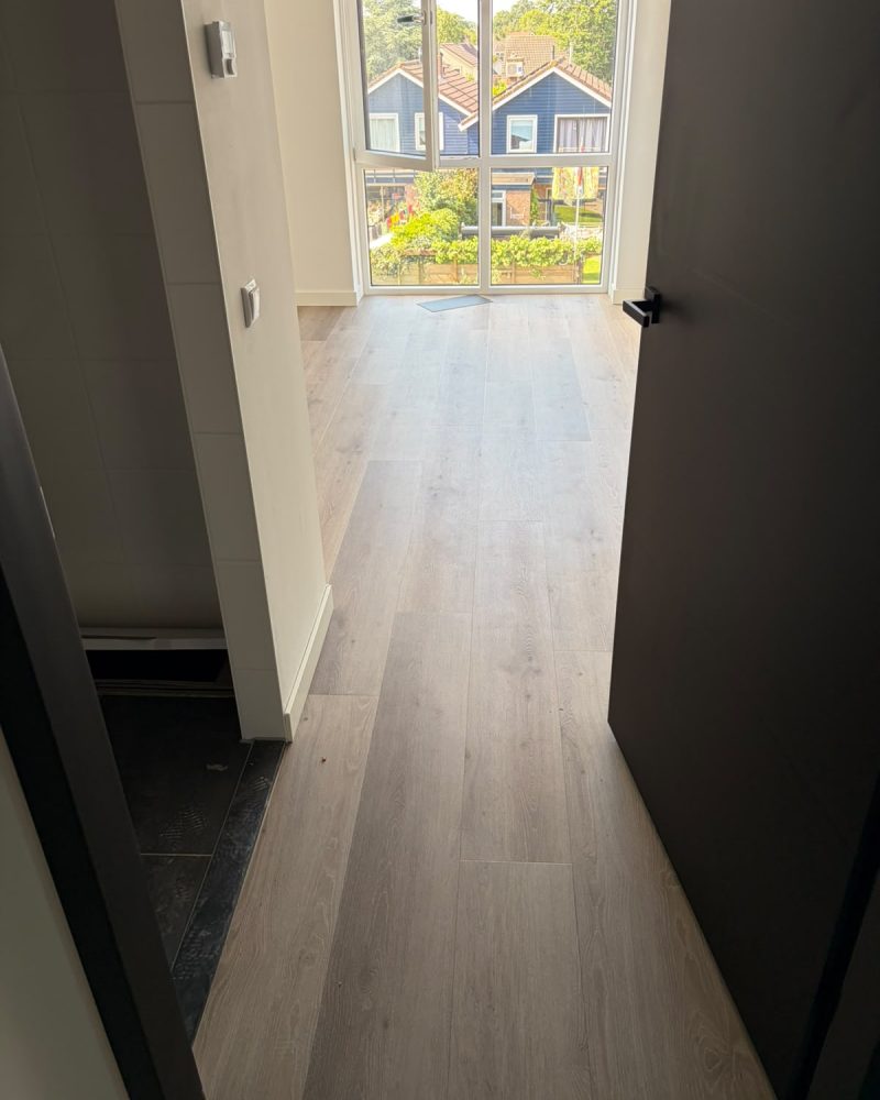 Lichte houtlook vloer gang met groot raam
