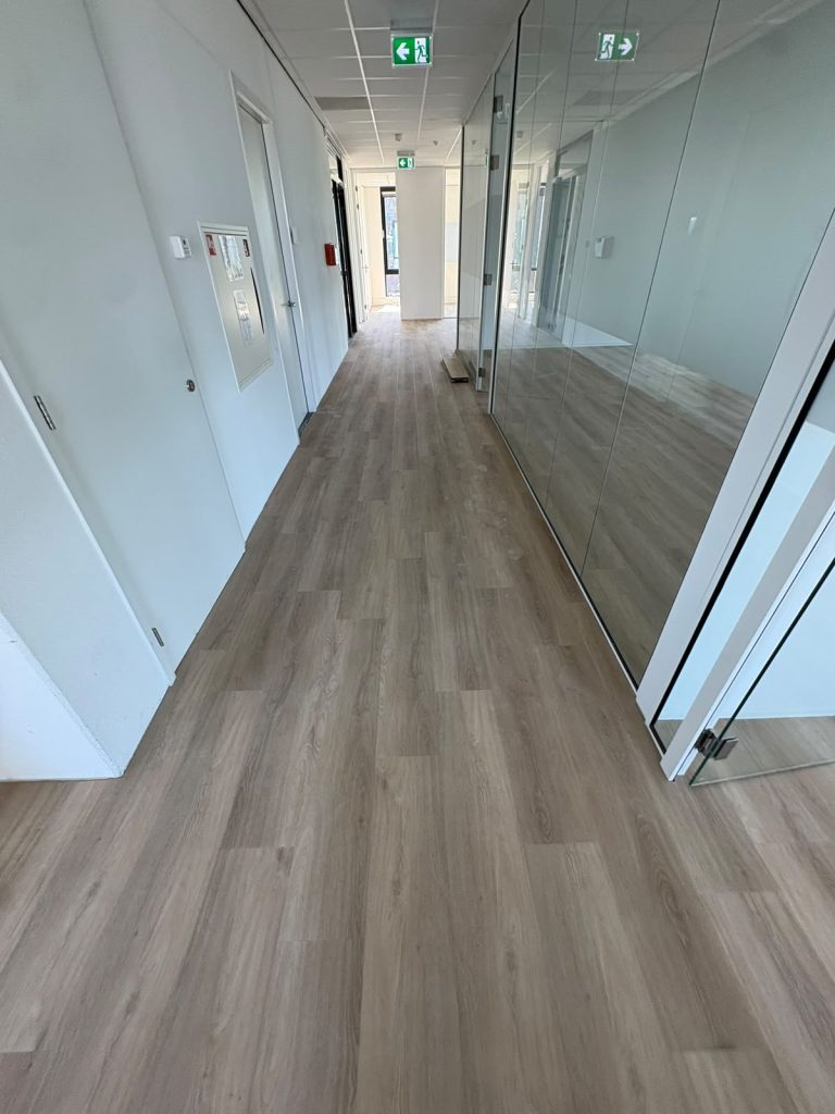 Lichte houtlook vloer kantoorgang met glazen wanden