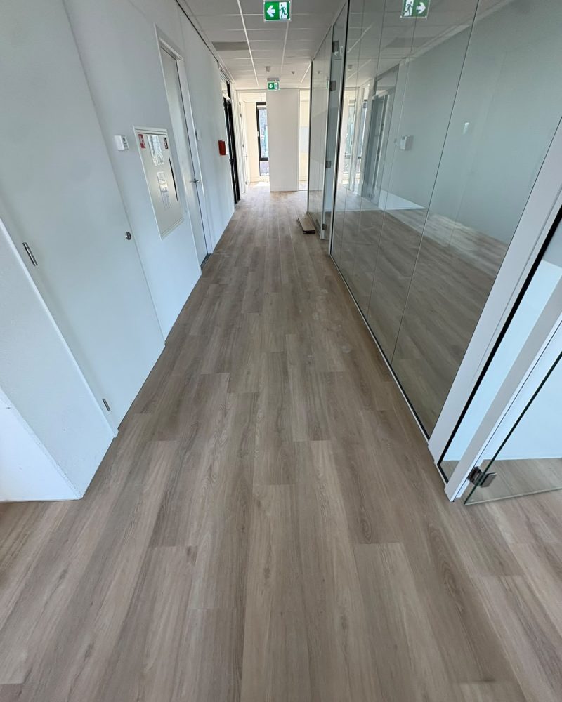 Lichte houtlook vloer kantoorgang met glazen wanden